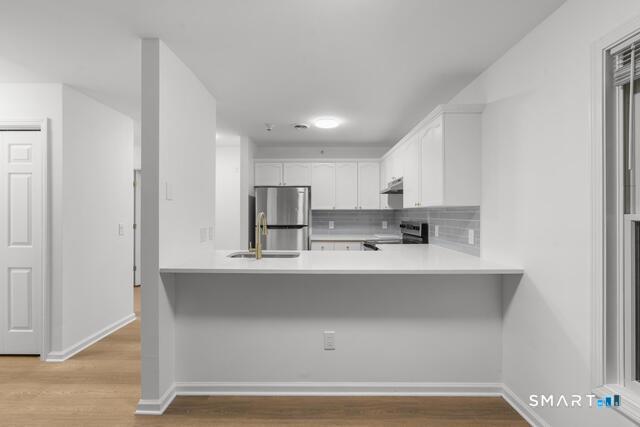 468 Main Street, Unit 318 East Lyme, CT 06357 - Photo 23 of 33 a view of a kitchen with stainless steel appliances cabinets and a window