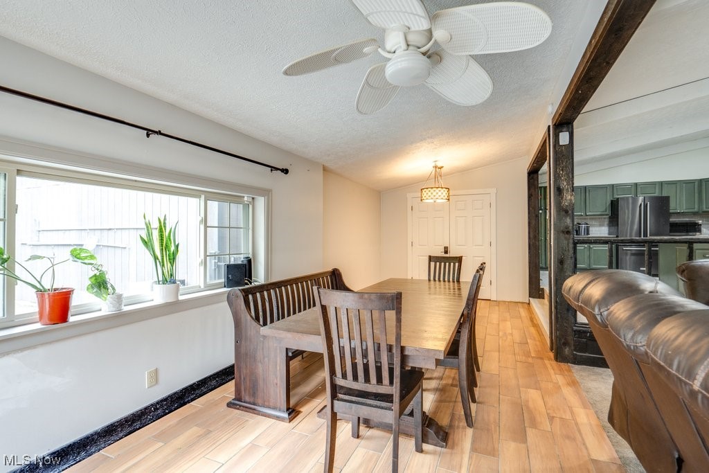 4100 Jade Road Northwest Carrollton, OH 44615 - Photo 11 of 37 Dining room with vaulted ceiling with beams, a textured ceiling, ceiling fan, and light hardwood / wood-style floors