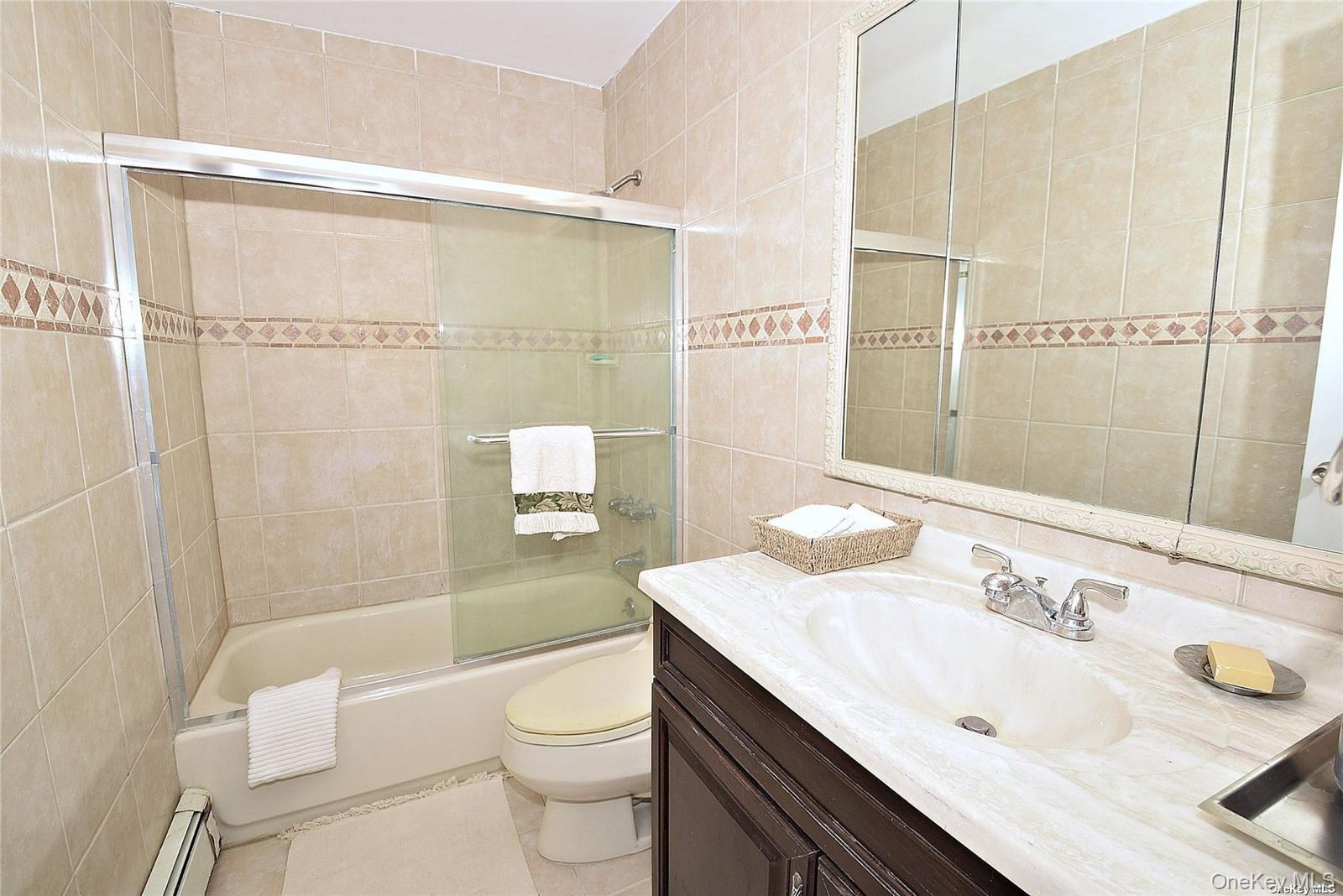 3434 Colony Drive Baldwin, NY 11510 - Photo 11 of 21 a bathroom with a sink a toilet and shower