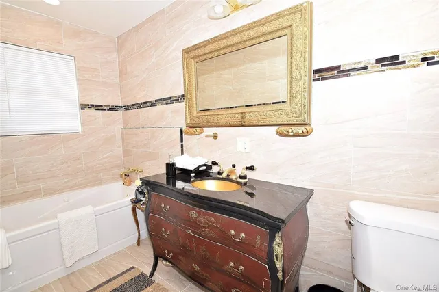 a bathroom with a sink mirror vanity and toilet