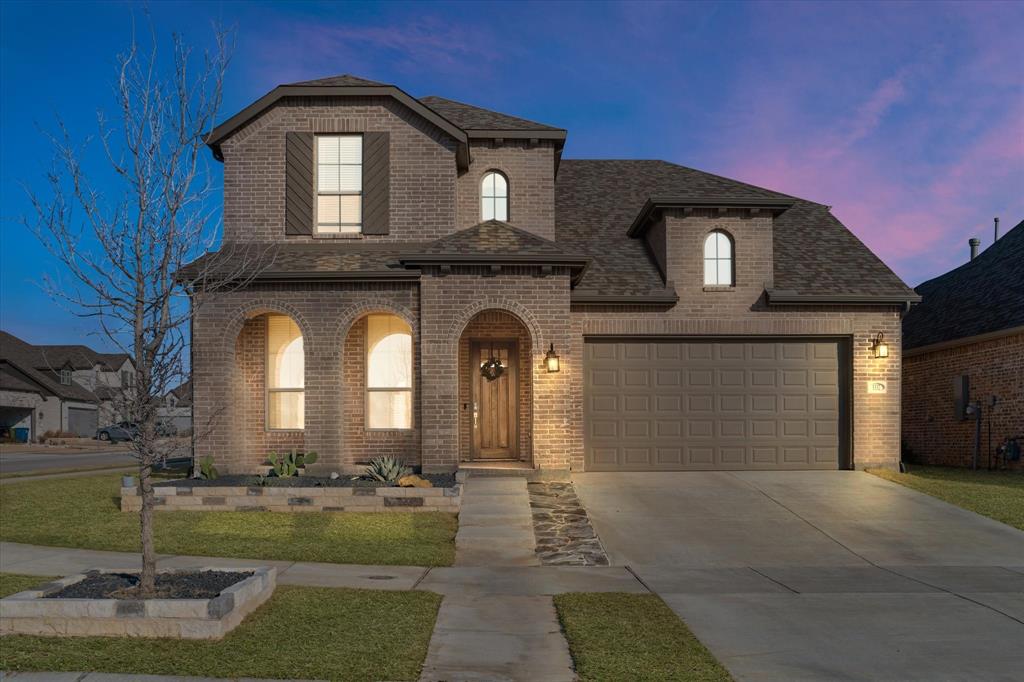 1332 Thompson Road Argyle, TX 76226 - Photo 1 of 36 French country style house featuring brick siding, driveway, a porch, a shingled roof, and a front yard
