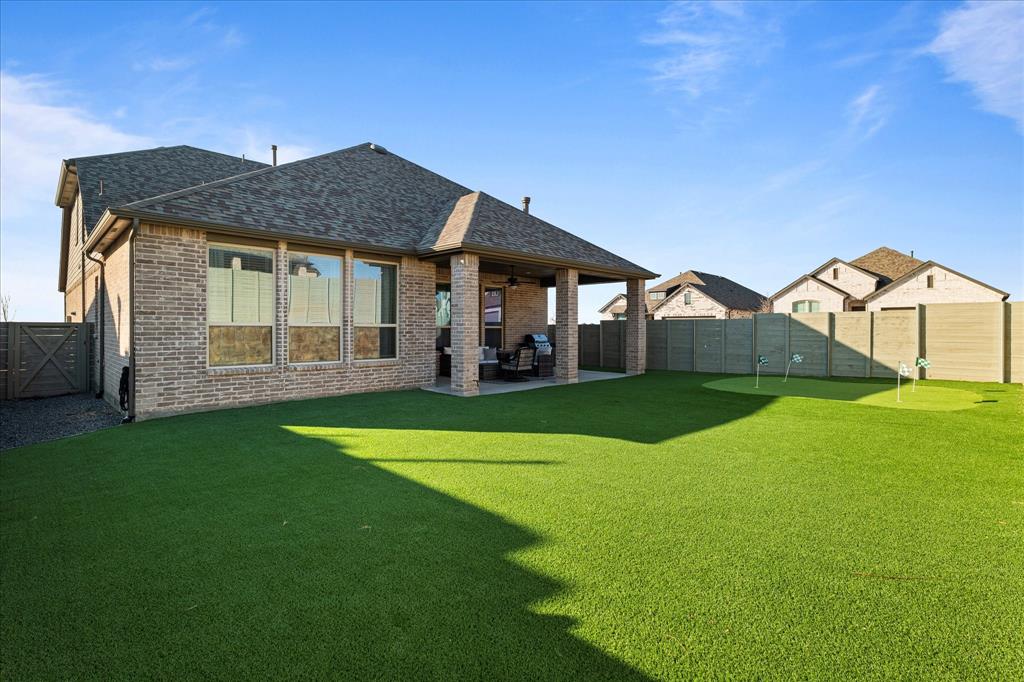1332 Thompson Road Argyle, TX 76226 - Photo 32 of 36 Back of house with brick siding, a patio, roof with shingles, and a fenced backyard