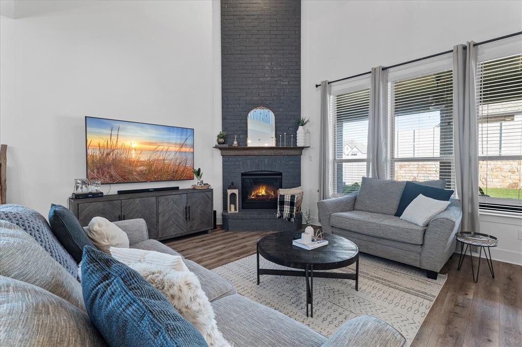 1332 Thompson Road Argyle, TX 76226 - Photo 6 of 36 Living room featuring a high ceiling, wood finished floors, and a fireplace