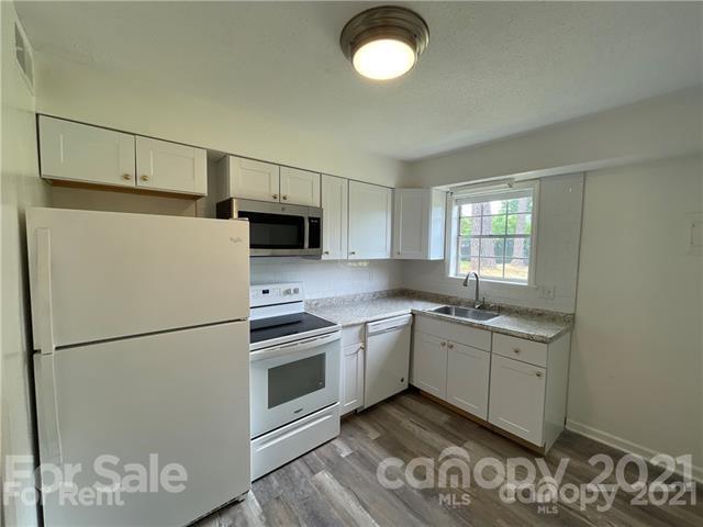 5805 Hunting Ridge Lane, Unit A Charlotte, NC 28212 - Photo 3 of 4 a kitchen with stainless steel appliances granite countertop a refrigerator sink and stove