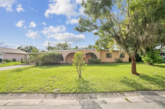 a front view of a house with a yard and lake