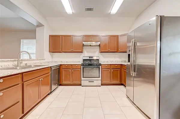 a kitchen with a refrigerator sink and cabinets