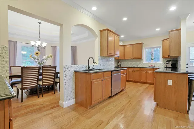 a kitchen with stainless steel appliances granite countertop a sink a stove a refrigerator cabinets and living room view