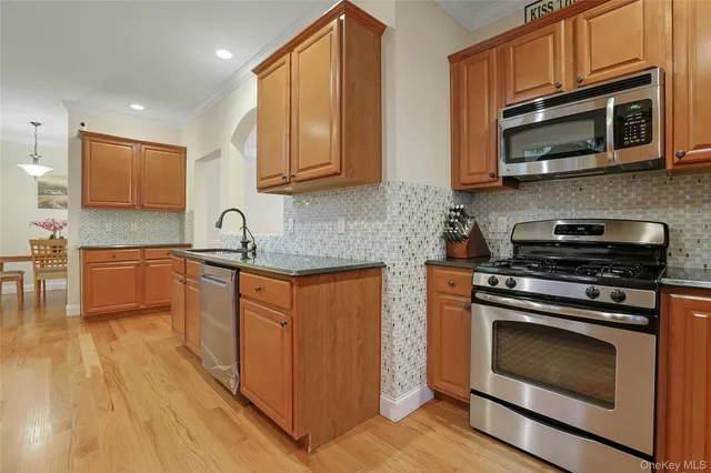 a kitchen with stainless steel appliances granite countertop a stove microwave and sink