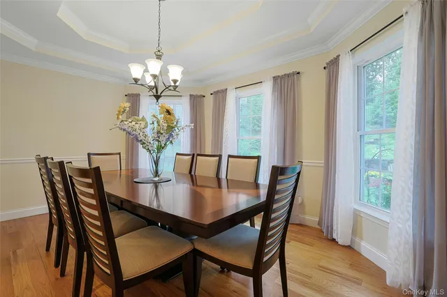 a view of a dining room with furniture a chandelier and wooden floor