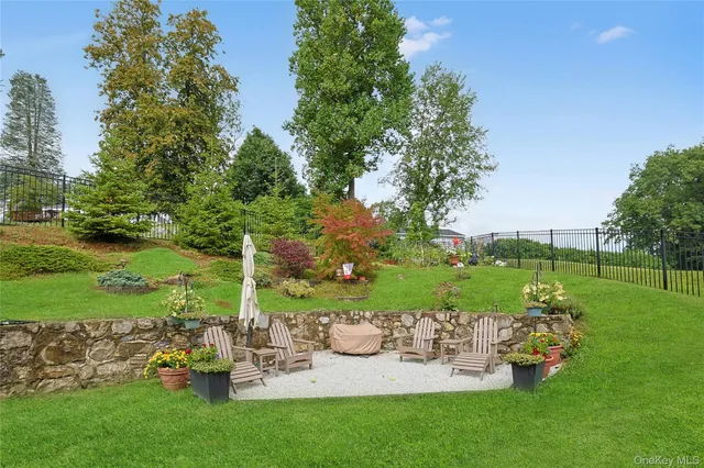 a view of a white house with large windows and a small yard