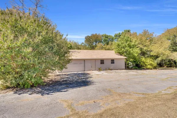 a view of a house with a yard and large tree