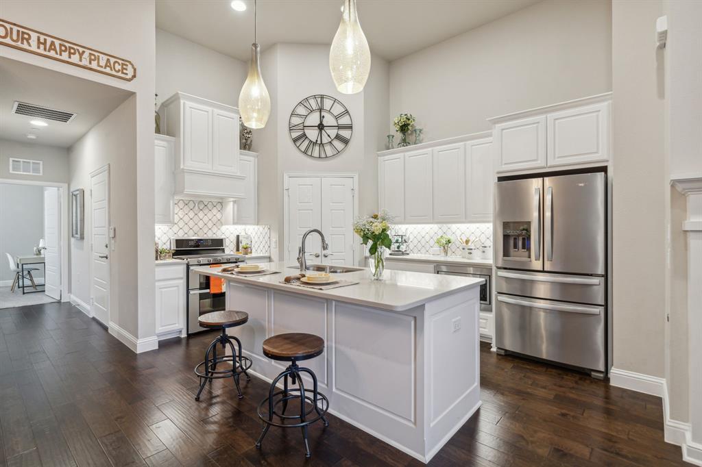 a kitchen with kitchen island white cabinets and stainless steel appliances