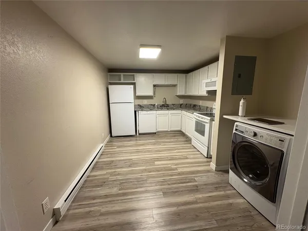 a view of kitchen with sink and refrigerator