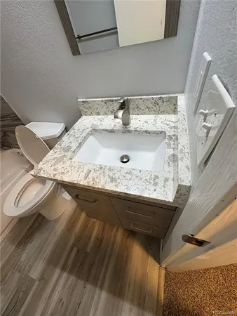 a bathroom with a granite countertop sink and a mirror