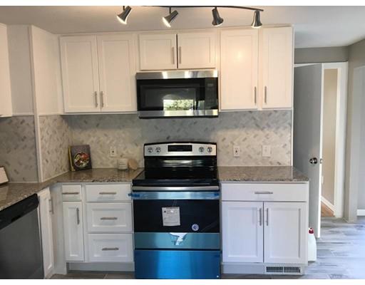 91 Windemere Street Springfield, MA 01104 - Photo 4 of 28 a kitchen with white cabinets and stainless steel appliances