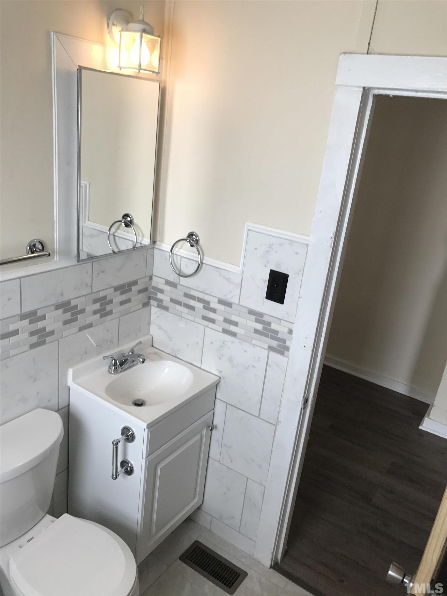 706 Coleman Street Raleigh, NC 27610 - Photo 2 of 5 a bathroom with a toilet sink and mirror