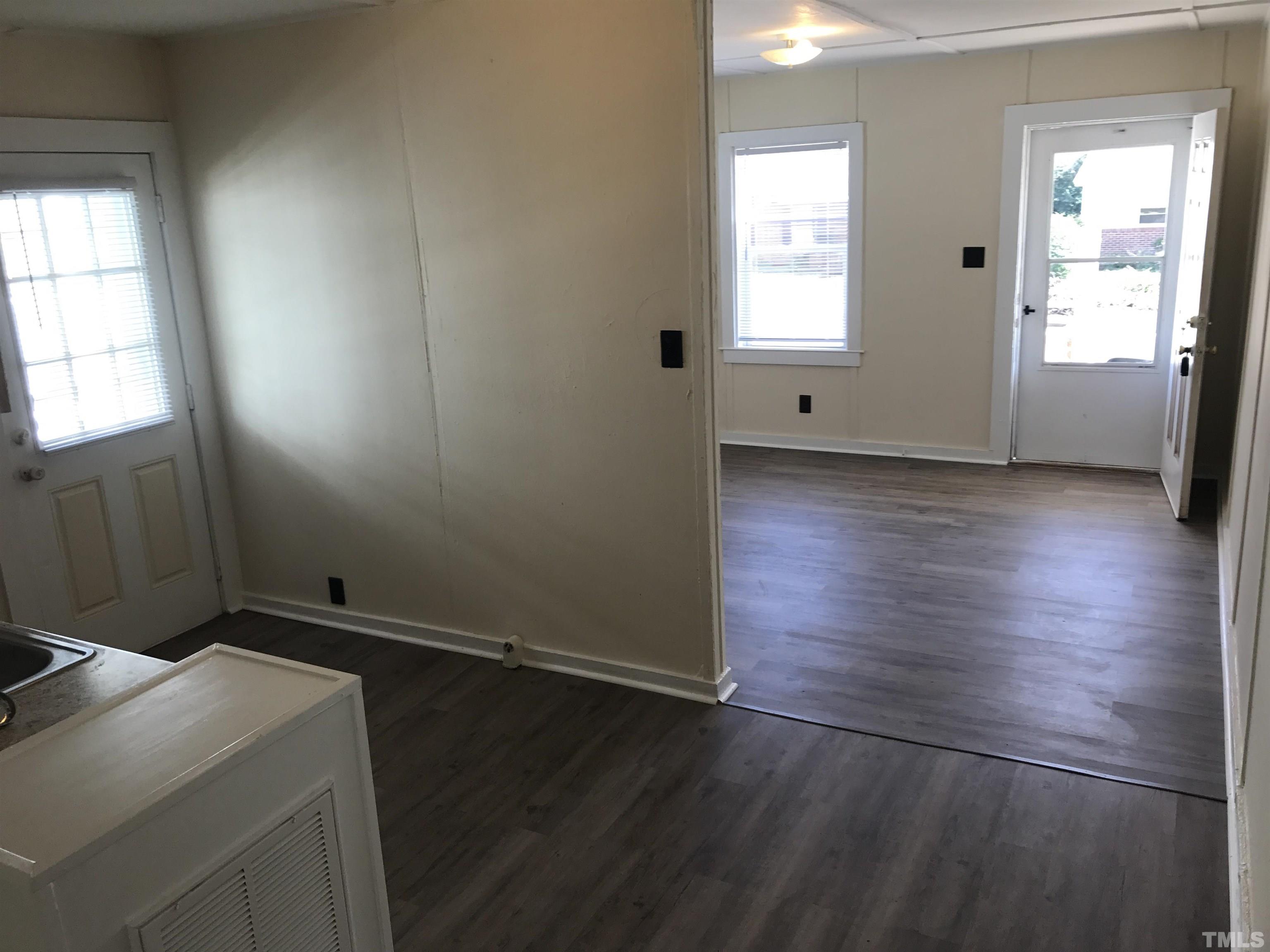 706 Coleman Street Raleigh, NC 27610 - Photo 3 of 5 an empty room with wooden floor and windows