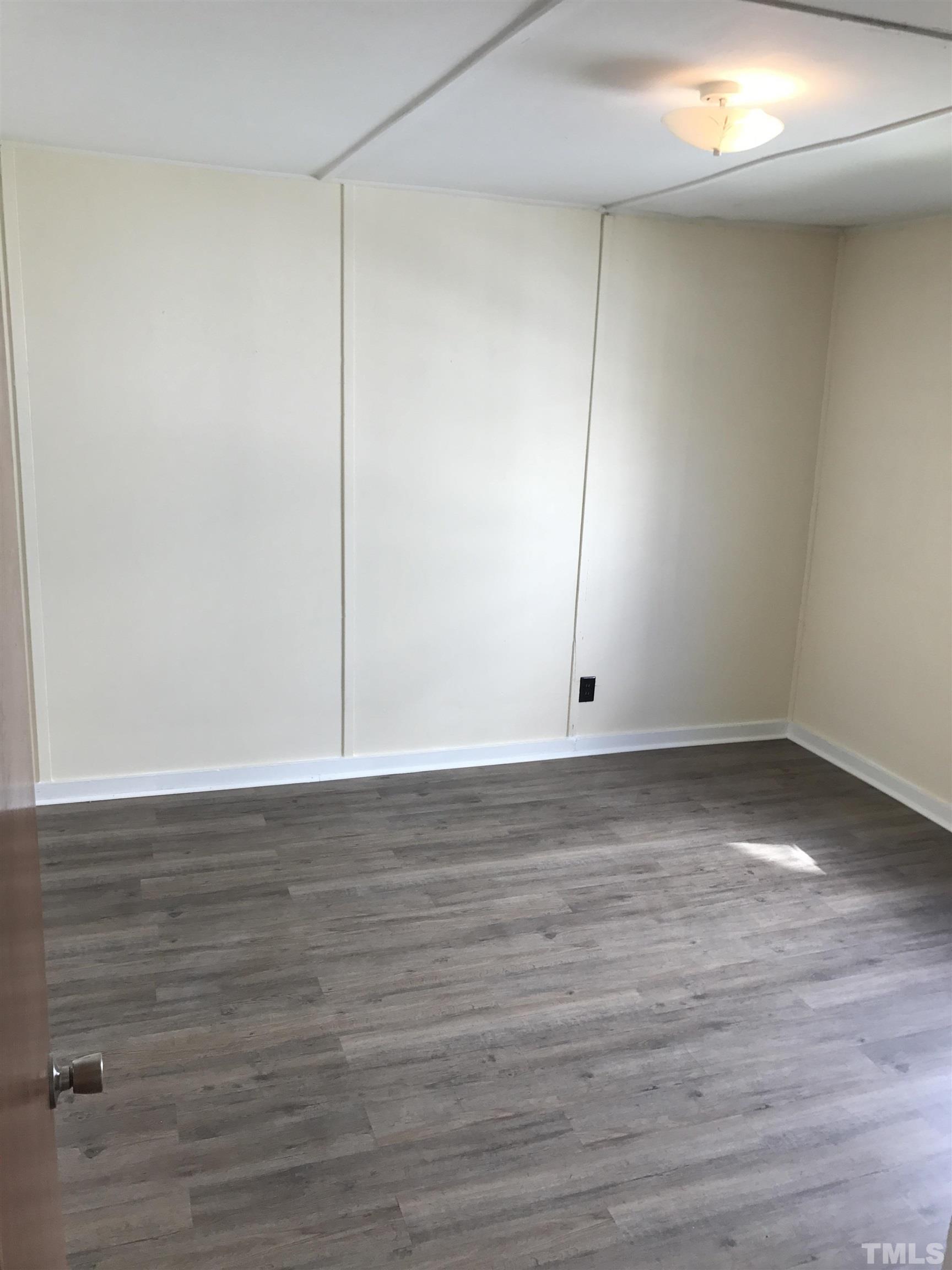 706 Coleman Street Raleigh, NC 27610 - Photo 4 of 5 a view of an empty room with wooden floor