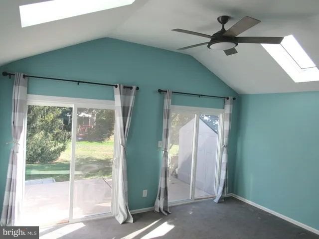 a view of a hallway with a ceiling fan and window