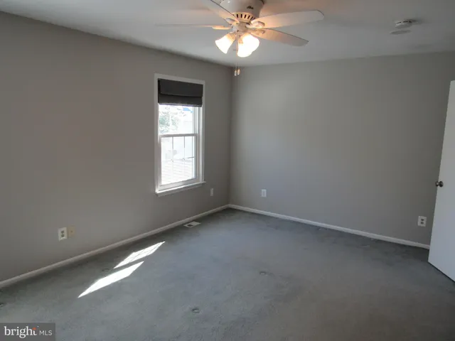 an empty room with chandelier fan