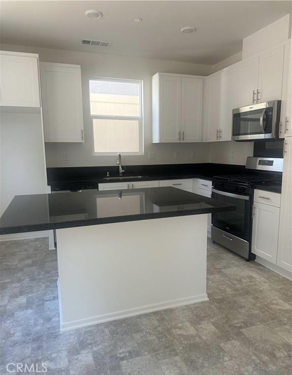 34254 Summer Lane Yucaipa, CA 92399 - Photo 2 of 2 a kitchen with granite countertop cabinets and white appliances