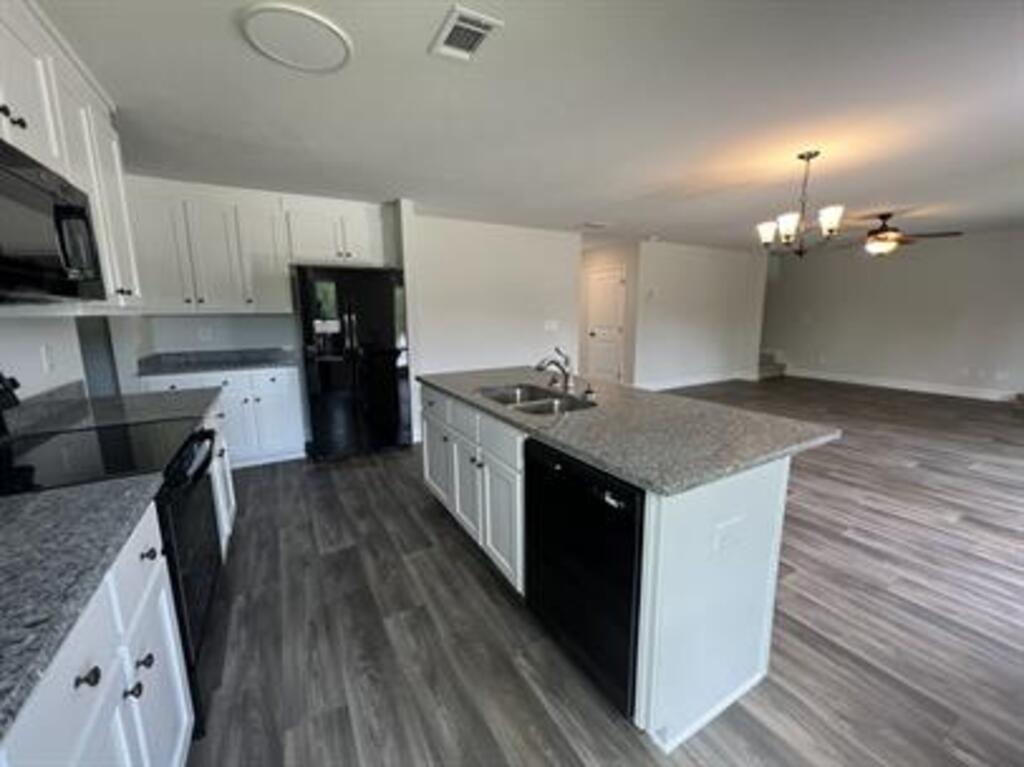 1389 River Mist Circle Jefferson, GA 30549 - Photo 5 of 18 a kitchen with a sink dishwasher a stove and a refrigerator with wooden floor
