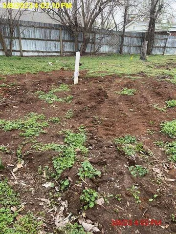 a backyard of a house with a yard and large trees