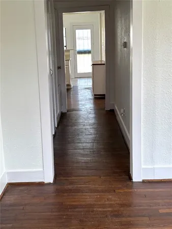 a view of a hallway with wooden floor
