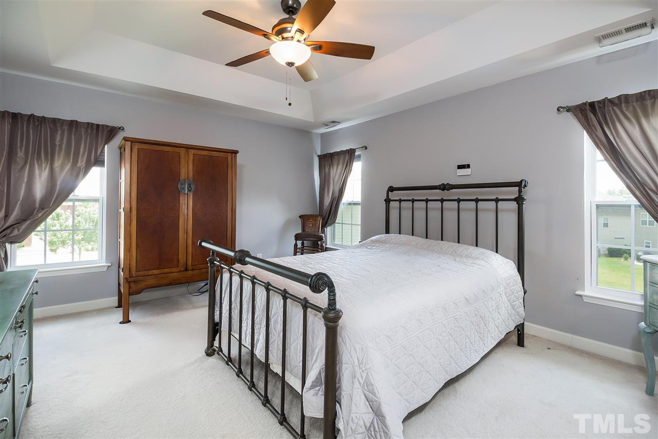 5160 Holly Ridge Farm Road Raleigh, NC 27616 - Photo 12 of 25 a bedroom with a bed and a chandelier