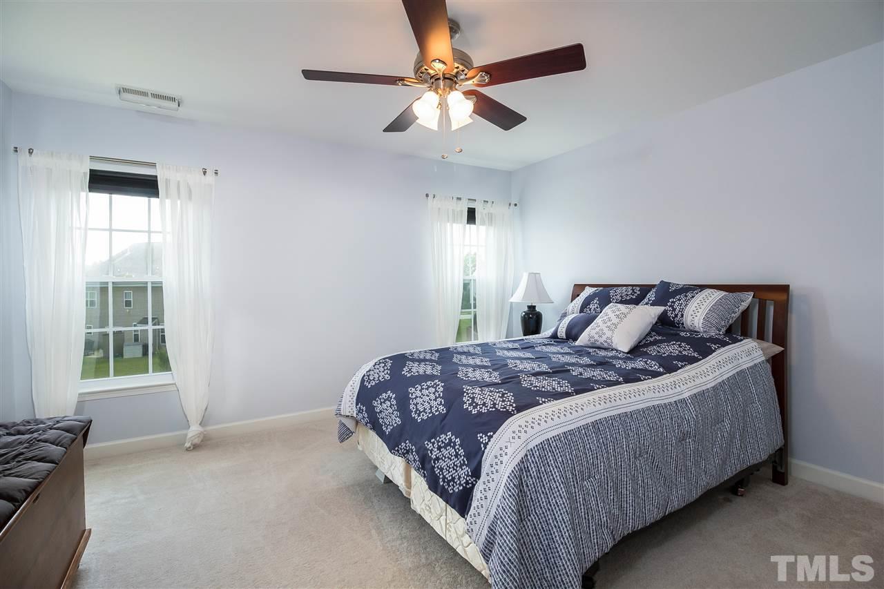 5160 Holly Ridge Farm Road Raleigh, NC 27616 - Photo 15 of 25 a bedroom with a bed and a ceiling fan