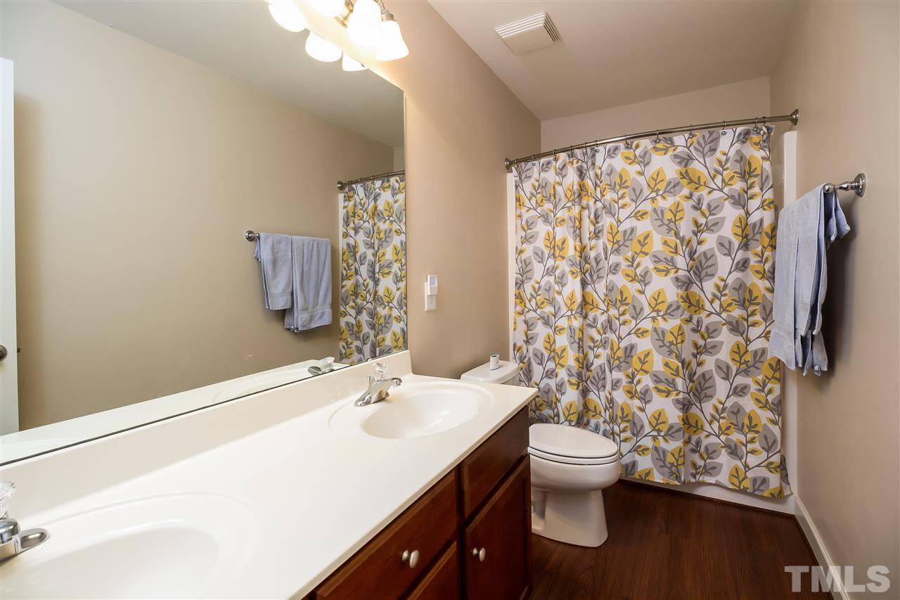 5160 Holly Ridge Farm Road Raleigh, NC 27616 - Photo 19 of 25 a bathroom with a sink a toilet and shower curtain