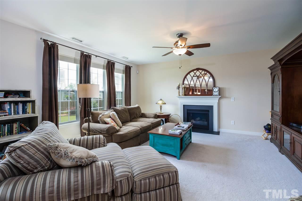 5160 Holly Ridge Farm Road Raleigh, NC 27616 - Photo 4 of 25 a living room with furniture a fireplace and a flat screen tv