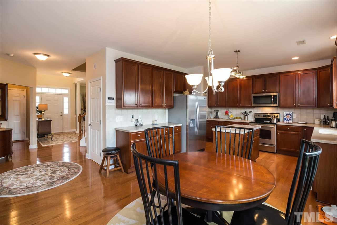 5160 Holly Ridge Farm Road Raleigh, NC 27616 - Photo 8 of 25 a kitchen with stainless steel appliances granite countertop a stove a refrigerator a kitchen island a dining table and chairs
