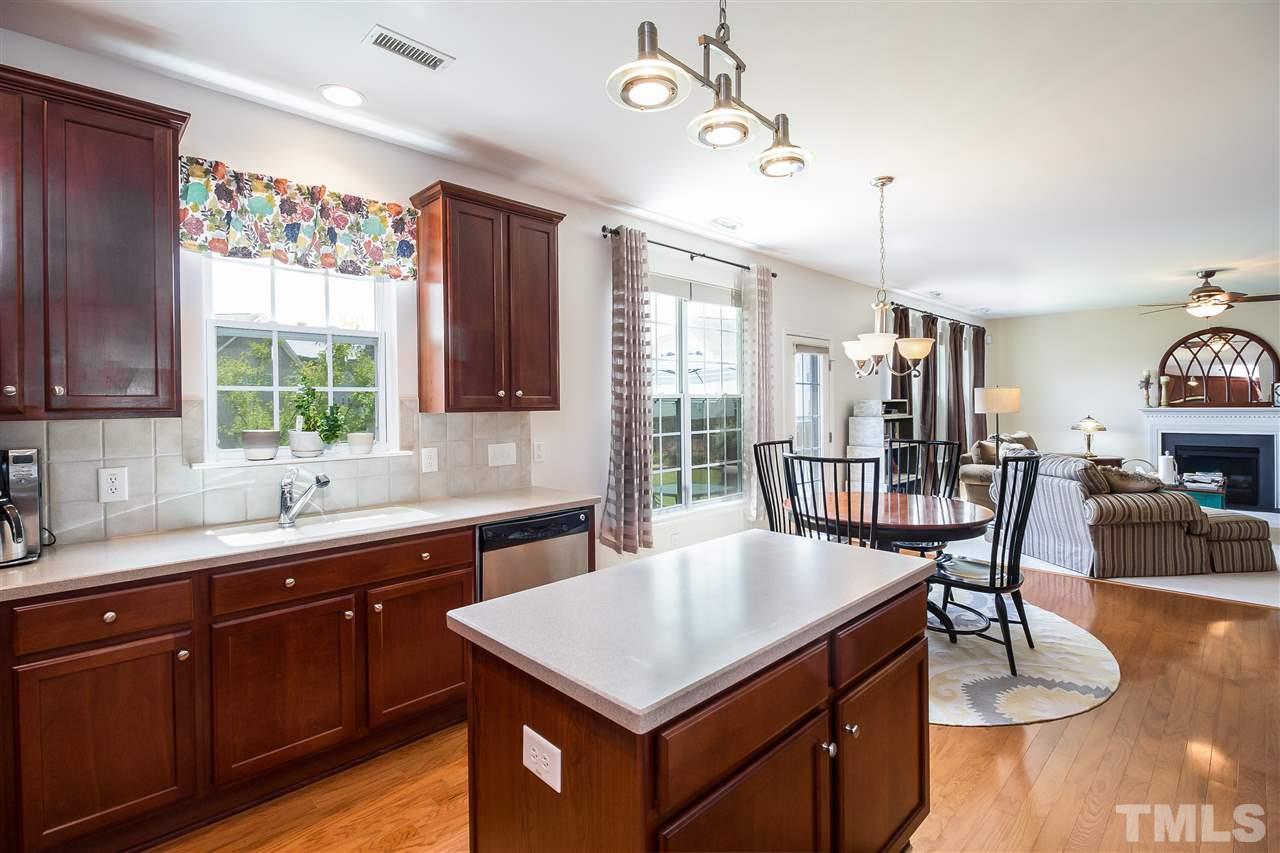 5160 Holly Ridge Farm Road Raleigh, NC 27616 - Photo 9 of 25 a kitchen with a kitchen island hardwood floor sink stove and dining table