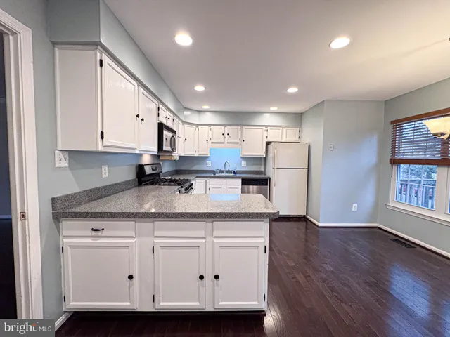 a view of a room with furniture and wooden floor