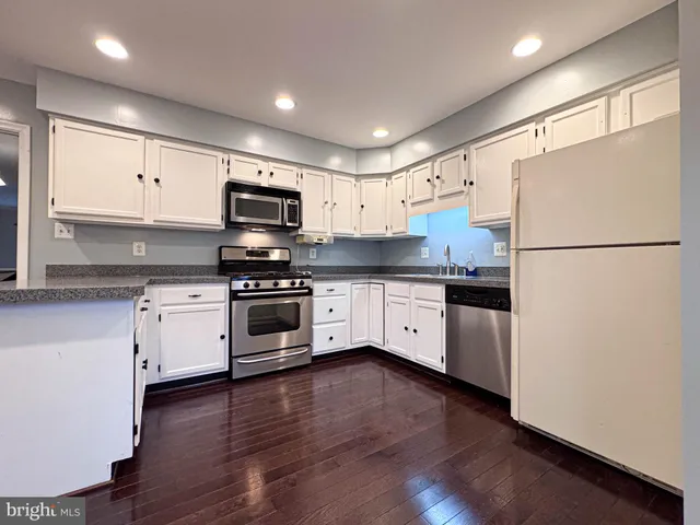 a view of a roof deck with table and chairs with wooden floor and fence