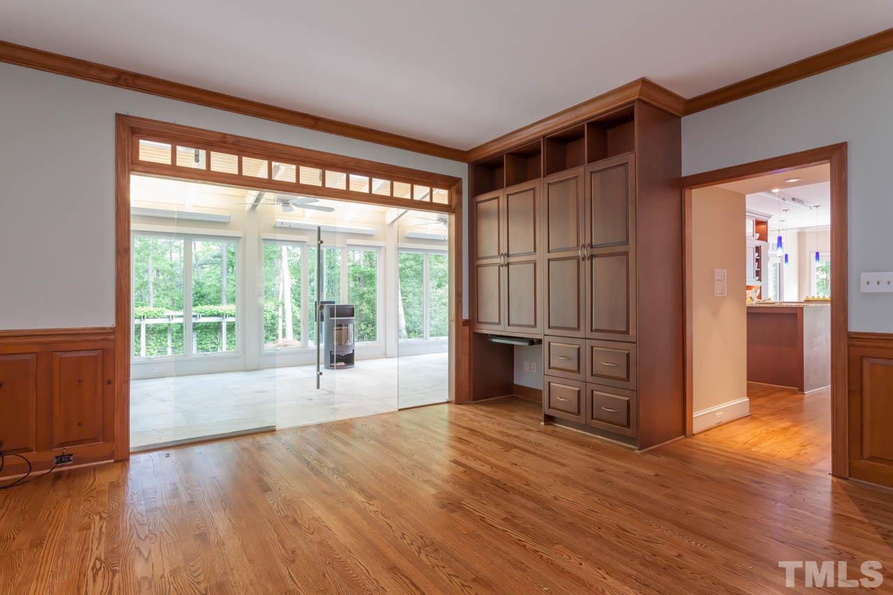 8016 Selfridge Court Raleigh, NC 27615 - Photo 13 of 25 a view of empty room with wooden floor and fireplace