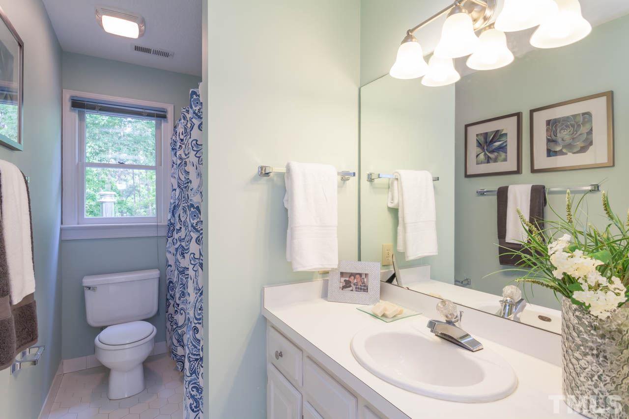 8016 Selfridge Court Raleigh, NC 27615 - Photo 18 of 25 a bathroom with a sink a toilet and a mirror