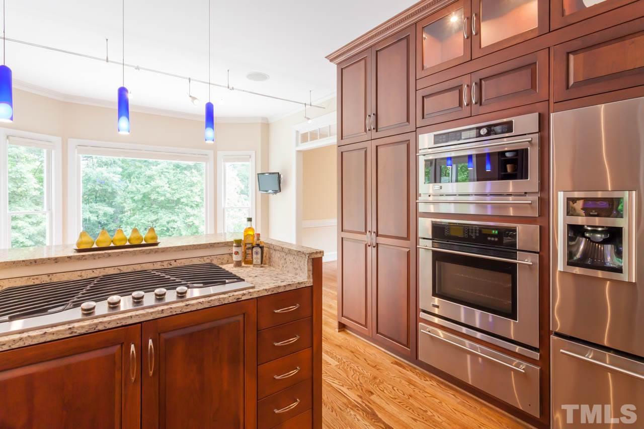 8016 Selfridge Court Raleigh, NC 27615 - Photo 6 of 25 a kitchen with stainless steel appliances granite countertop a stove and a refrigerator
