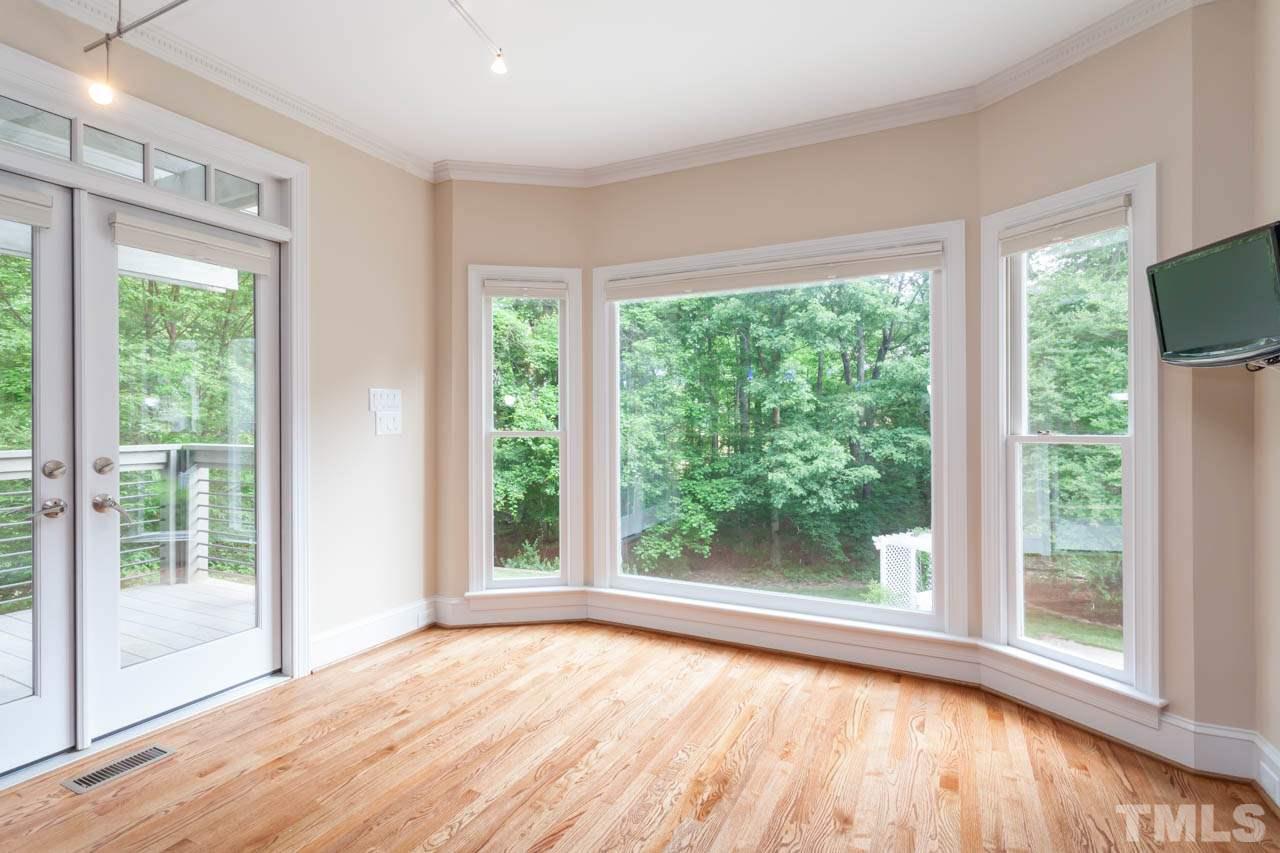 8016 Selfridge Court Raleigh, NC 27615 - Photo 8 of 25 a view of an empty room with wooden floor and a window
