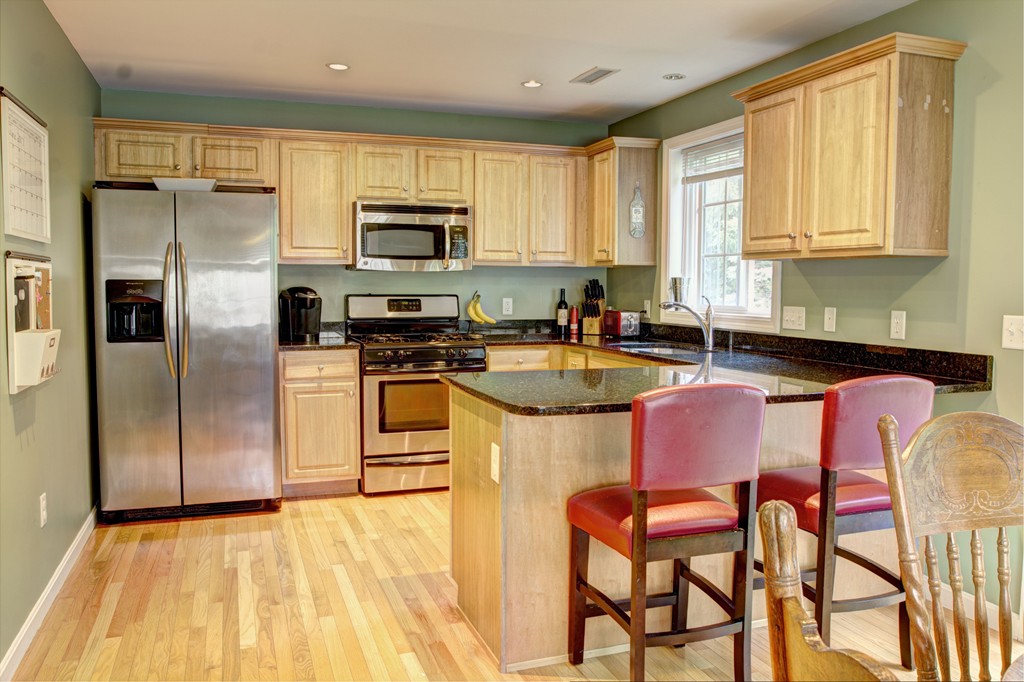 262 Littleton Road, Unit 22 Chelmsford, MA 01824 - Photo 3 of 30 a kitchen with stainless steel appliances granite countertop a stove a sink a microwave and a refrigerator