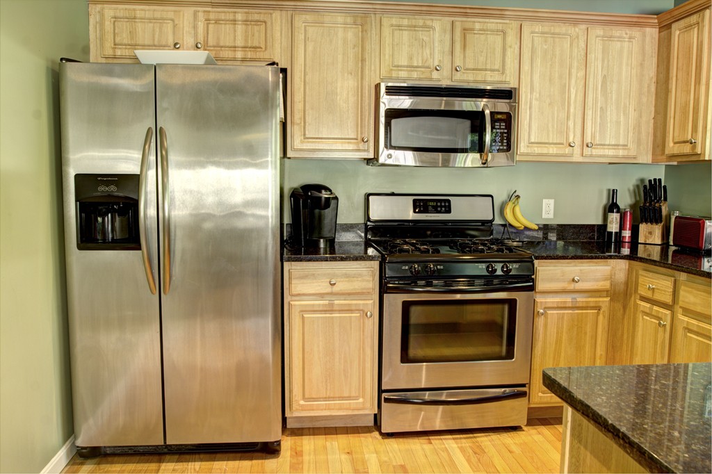 262 Littleton Road, Unit 22 Chelmsford, MA 01824 - Photo 6 of 30 a kitchen with stainless steel appliances granite countertop a refrigerator stove and microwave