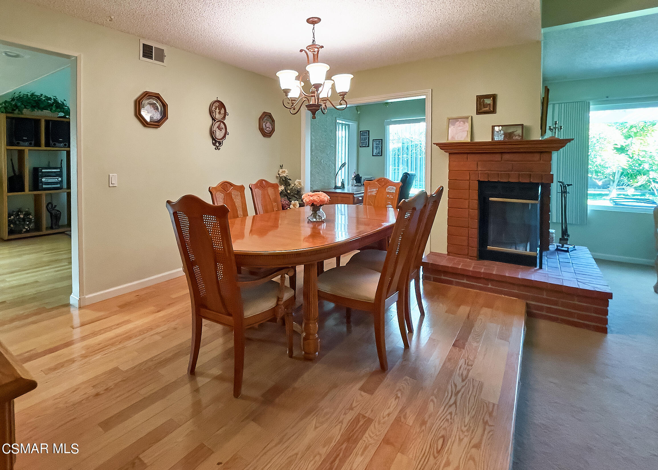 4110 Oakcliff Drive Moorpark, CA 93021 - Photo 17 of 67 a dining room with furniture wooden floor a potted plant a fireplace and a chandelier
