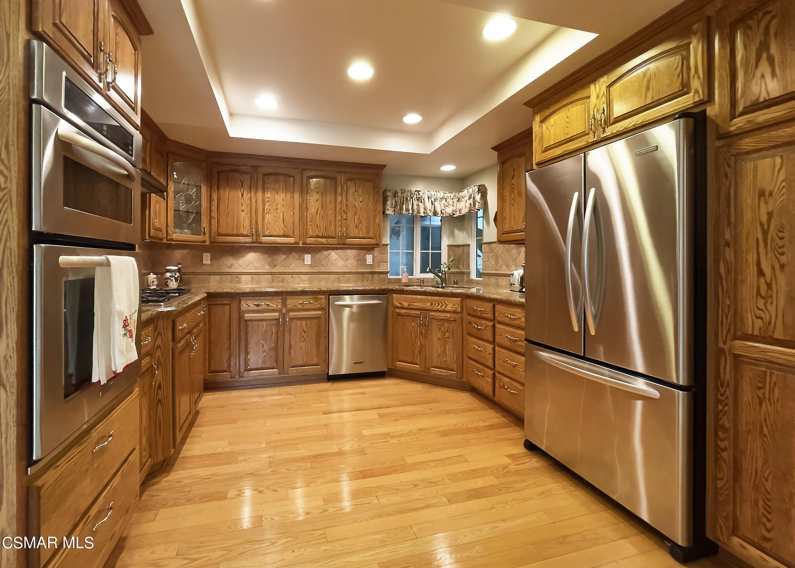 4110 Oakcliff Drive Moorpark, CA 93021 - Photo 37 of 67 a kitchen with stainless steel appliances granite countertop a refrigerator a sink and white cabinets