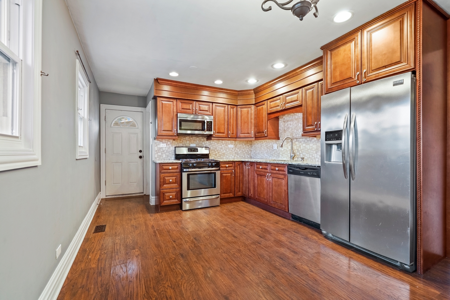 5932 107th Place Chicago Ridge, IL 60415 - Photo 5 of 22 a kitchen with stainless steel appliances a refrigerator and a wooden floor