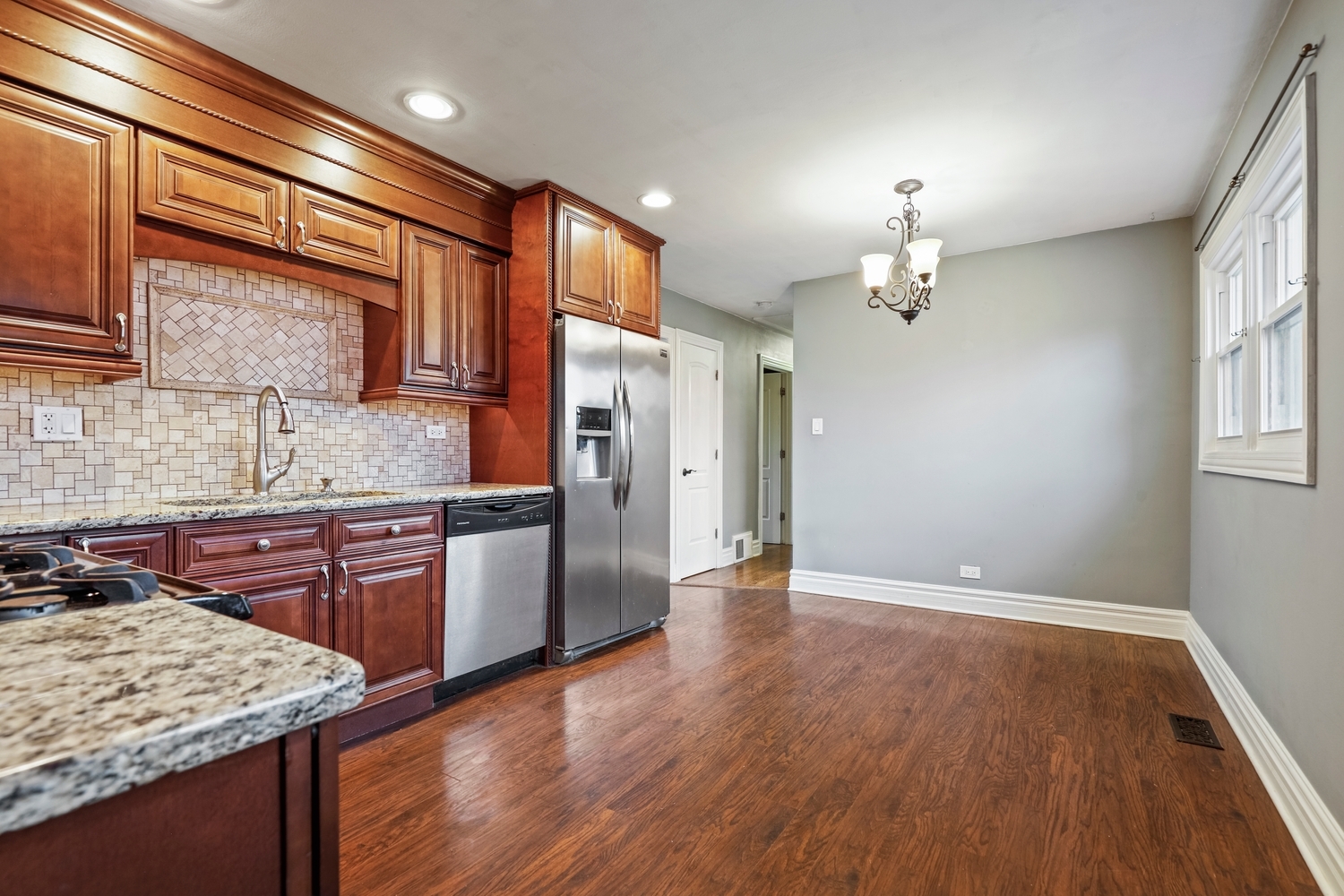 5932 107th Place Chicago Ridge, IL 60415 - Photo 6 of 22 a kitchen with stainless steel appliances granite countertop hardwood floor sink stove and granite counter top