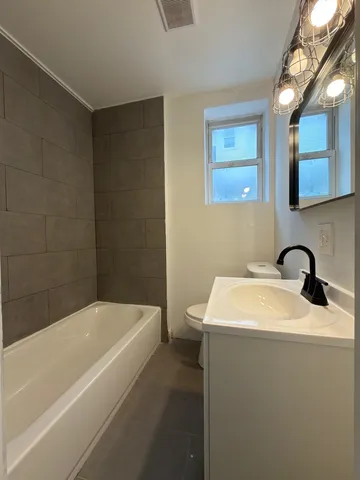 a bathroom with a sink a bathtub and a window