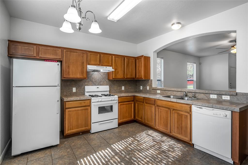 2518 Allred Drive, Unit A Austin, TX 78748 - Photo 2 of 16 Kitchen featuring white appliances, wood finish cabinets, decorative light fixtures, backsplash, and ceiling fan