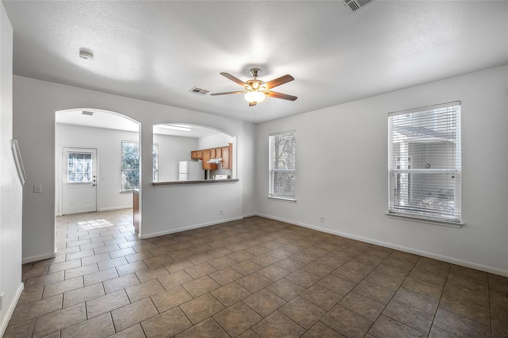 2518 Allred Drive, Unit A Austin, TX 78748 - Photo 4 of 16 Unfurnished room with ceiling fan, arched walkways, healthy amount of natural light, and dark tile patterned flooring