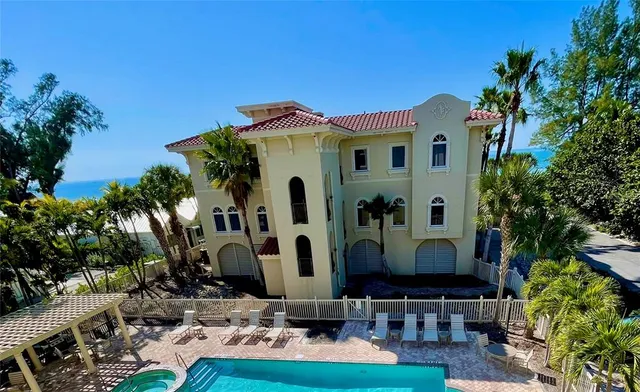 an aerial view of ocean and residential houses with outdoor space